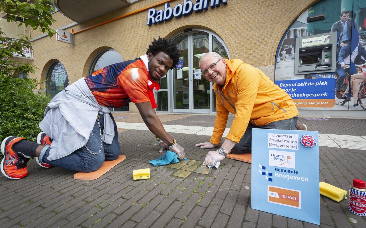 Kenneth Ezuruike Chigozie (27) en buddy Dick van Dam poetsen de Stolpersteine in Het Haagje.