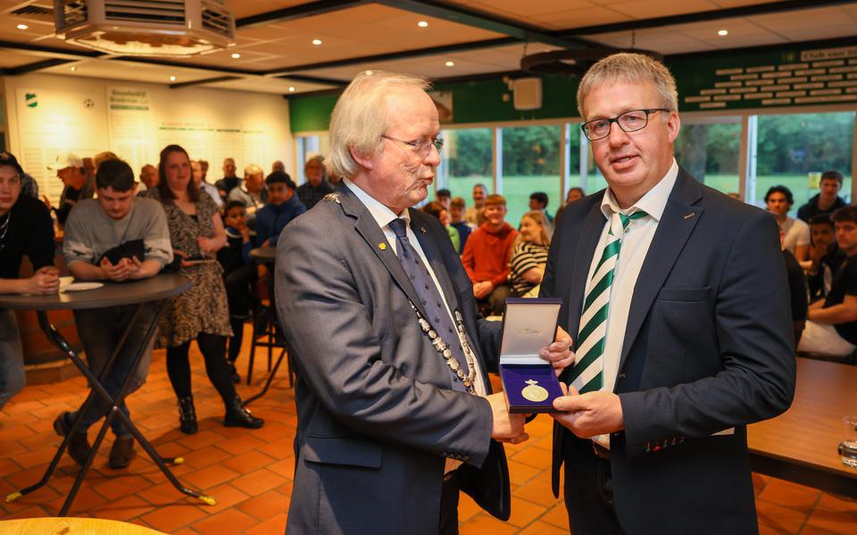 Burgemeester Rikus Jager van de gemeente Westerveld overhandigt de onderscheiding aan Old Forward-voorzitter Johan Bergsma.