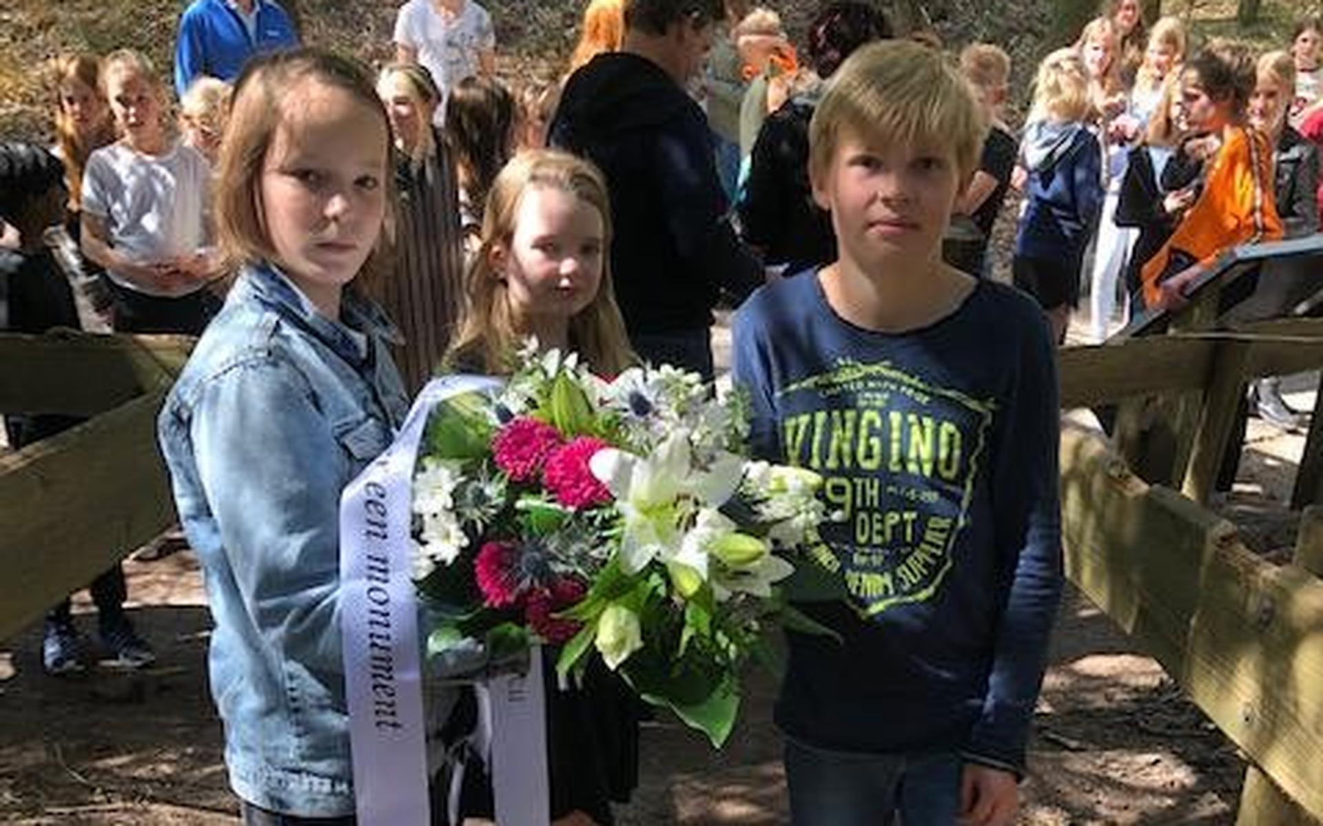 Kinderen uit Wapse en Diever zetten na twee jaar coronastop traditie voort: een bloemstuk bij het on
