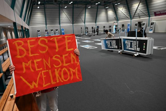 Drukke bedoening in- en rond sporthal De Slenken in de Wijk voor nachtopvang vluchtelingen