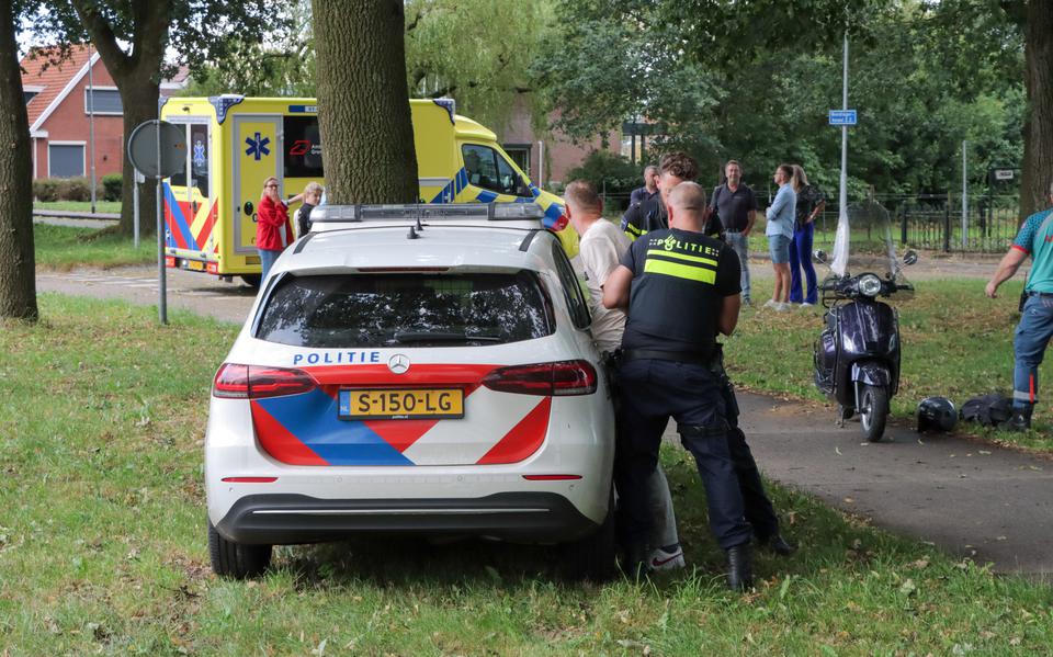 Scooterpassagier valt na ongeluk in Nieuw-Weerdinge ambulancepersoneel aan en wordt in de boeien geslagen.