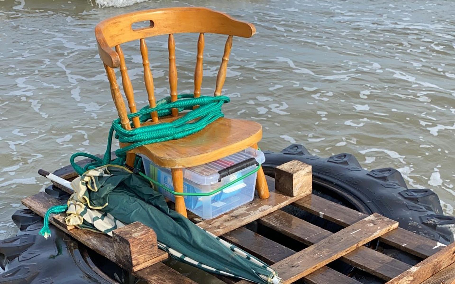 Raft with chair, parasol, filled cakes and water washes up on Schiermonnikoog