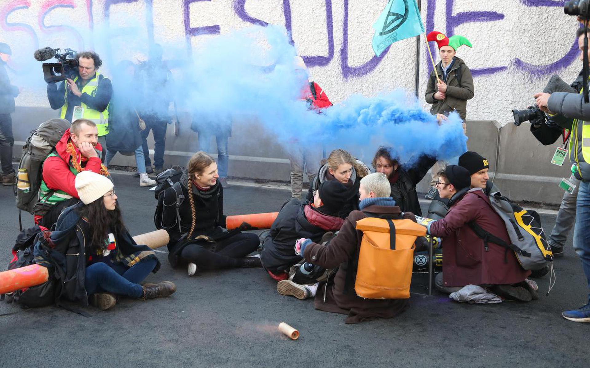 Demonstranten hebben zich op verschillende manieren aan elkaar en aan de weg vastgemaakt uit protest tegen de miljarden die Nederland uitgeeft aan subsidies voor producenten van fossiele brandstoffen.