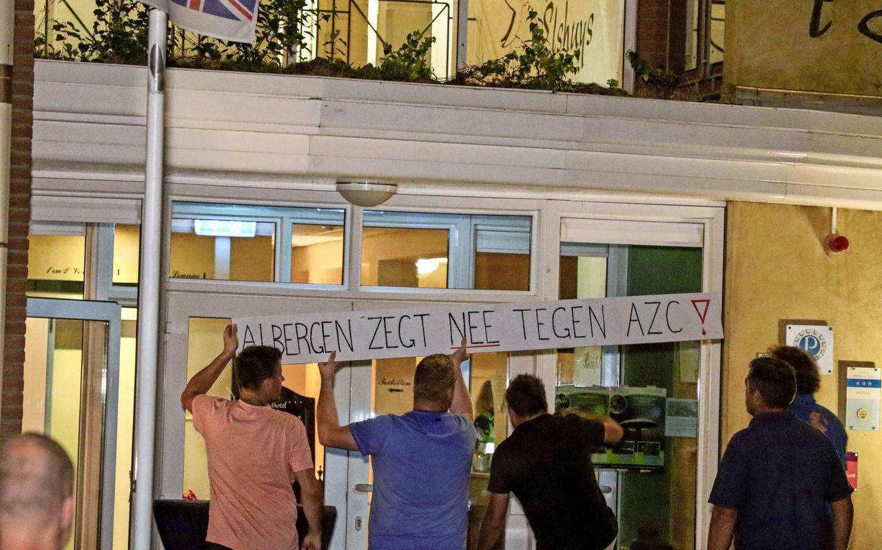 Boze bewoners van Albergen hangen een protestbord op bij hotel ’t Elshuys, dat door het kabinet is aangewezen als opvangplek voor asielzoekers.