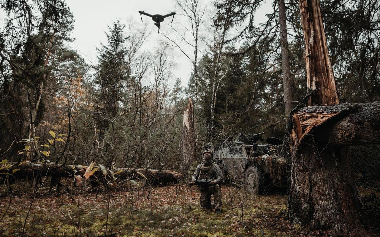 Snorrend schiet een muisgrijze Atlas-drone omhoog tussen de bomen. Snorrend schiet een muisgrijze Atlas-drone omhoog tussen de bomen.