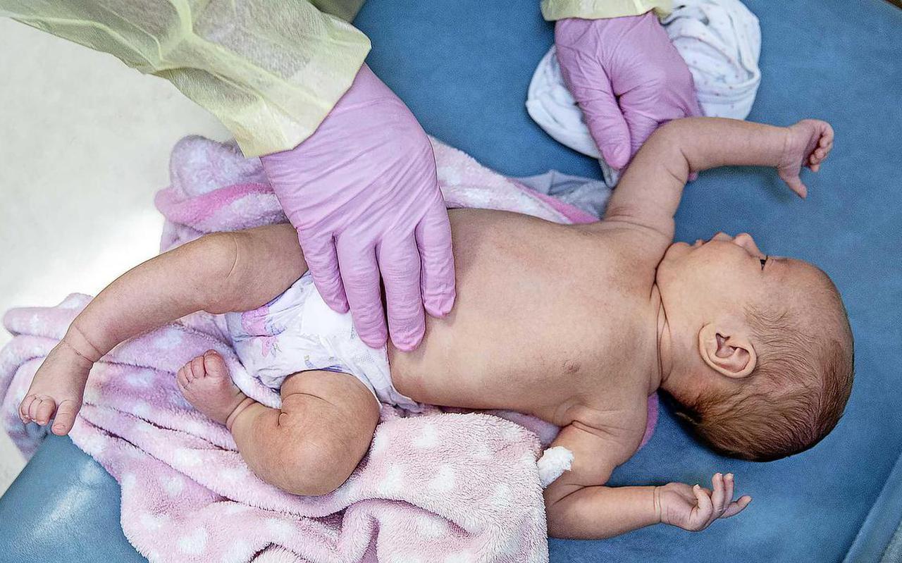 Een arts onderzoekt een baby in een kliniek in de Verenigde Staten op de verschijnselen van het RS-virus. De symptomen zijn kortademigheid en een piepende ademhaling.