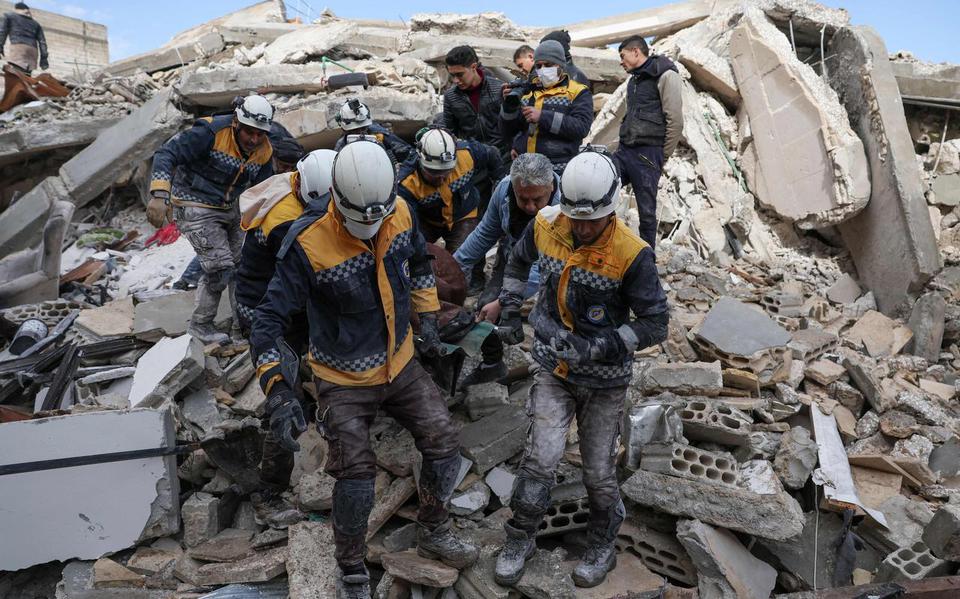 TOPSHOT - Members of the Syrian civil defence, known as the White Helmets, transport a casualty from the rubble of buildings in the village of Azmarin in Syria's rebel-held northwestern Idlib province at the border with Turkey following an earthquake, on February 7, 2023. (Photo by Omar HAJ KADOUR / AFP)