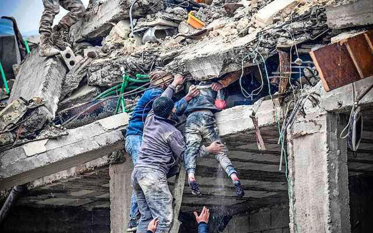 Reddingswerkers halen een meisje levend vanonder het puin in Jindires, Syrië.