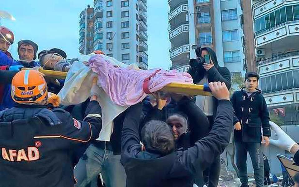Hulpverleners halen een kind uit het puin in de Turkse stad Adana.