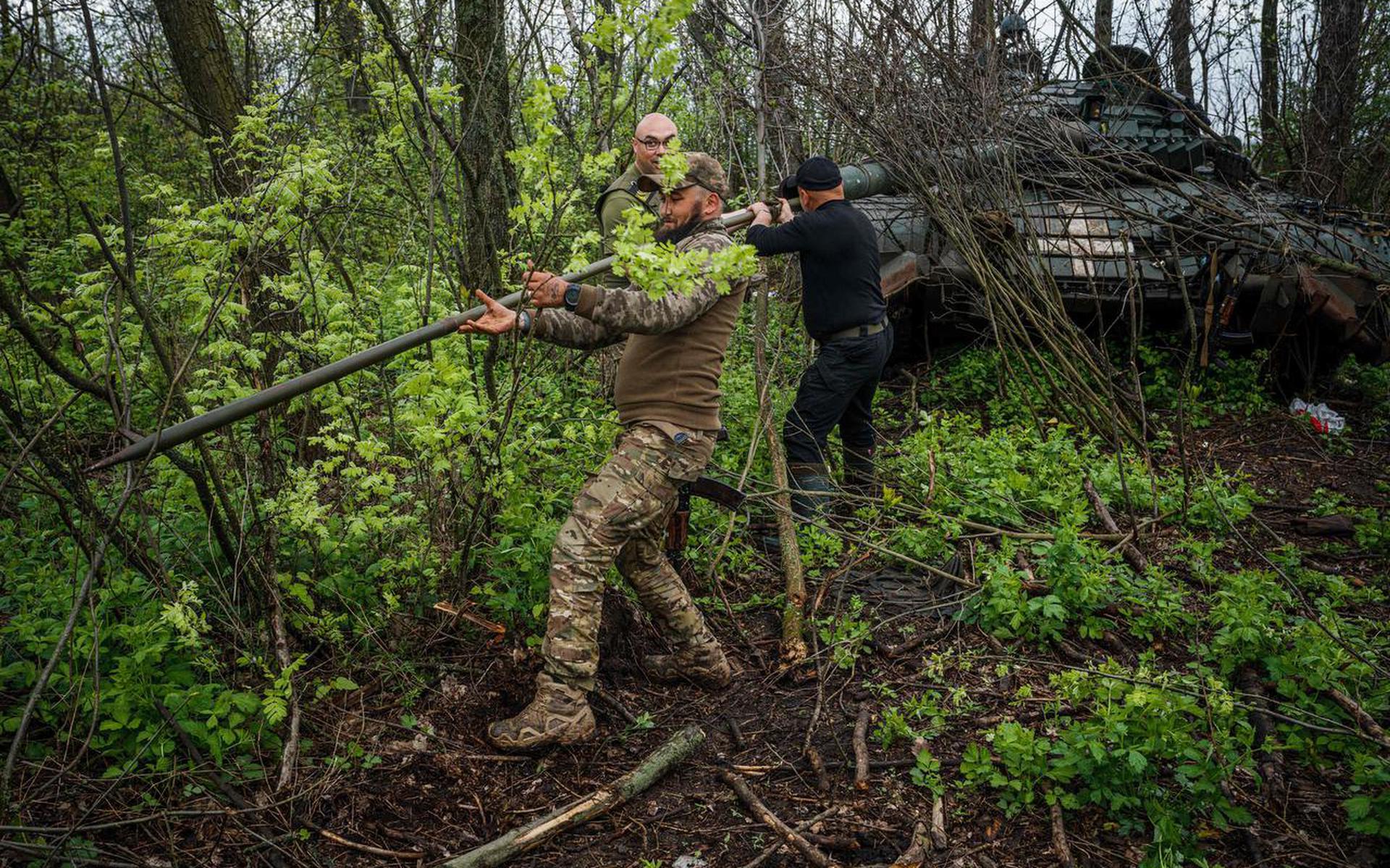 Oekraïense militairen maken het geschut van hun tank schoon bij de stad Bachmoet.