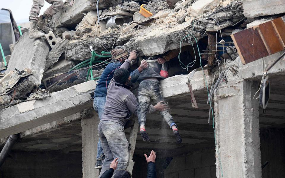 Reddingswerkers halen een gewond meisje uit de brokstukken van een ingestort gebouw in Jandaris, in Syrië.