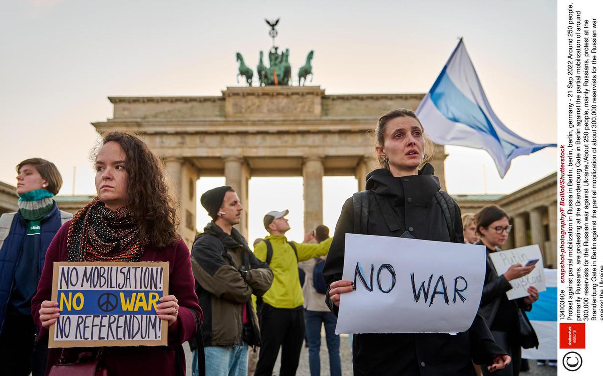 Zo'n 250 Russen demonstreren bij de Brandenburger Poort in Berlijn tegen de gedeeltelijke mobilisatie in Rusland. Honderduizenden jonge Russen zijn inmiddels hun land ontvlucht om aan de mobilisatie te ontkomen.