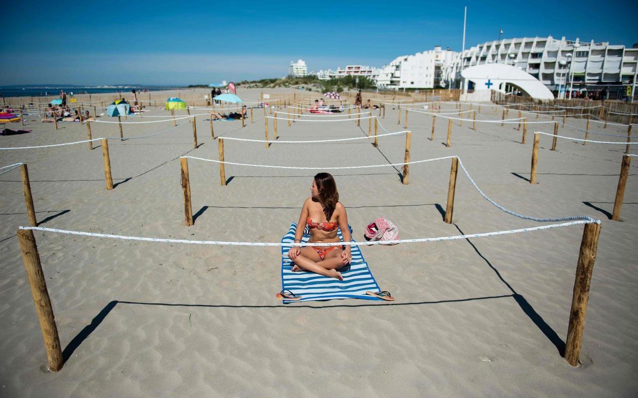 Op het strand van La Grande Motte, in het zuiden van Frankrijk, is duidelijk aangegeven hoeveel afstand bezoekers van elkaar moeten houden. Op het strand van La Grande Motte, in het zuiden van Frankrijk, is duidelijk aangegeven hoeveel afstand bezoekers van elkaar moeten houden.