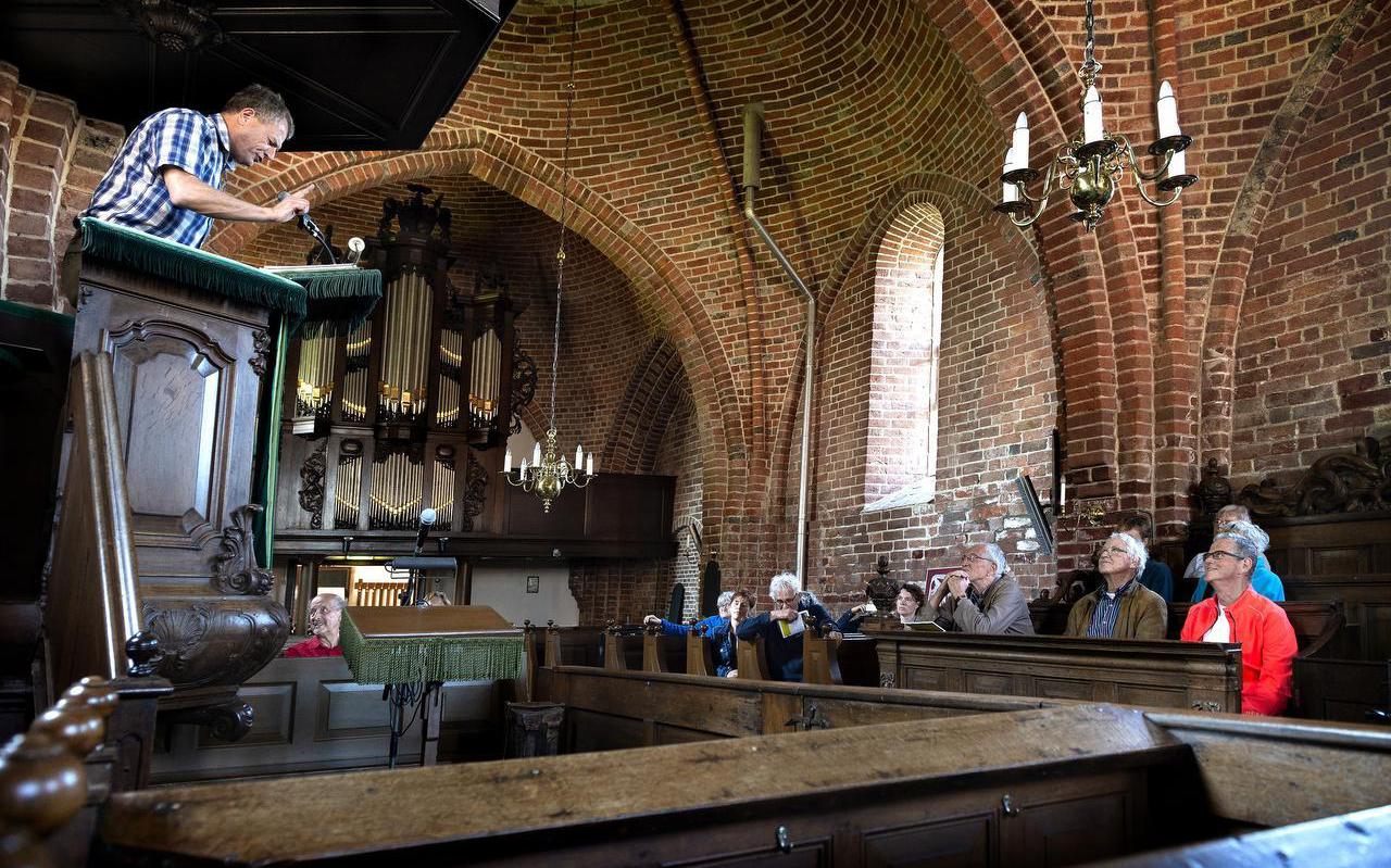 Gids Marcel de Jong sloot de wandeling af met een Cocksiaanse preek in de kerk van Ulrum.  Foto Peter Wassing