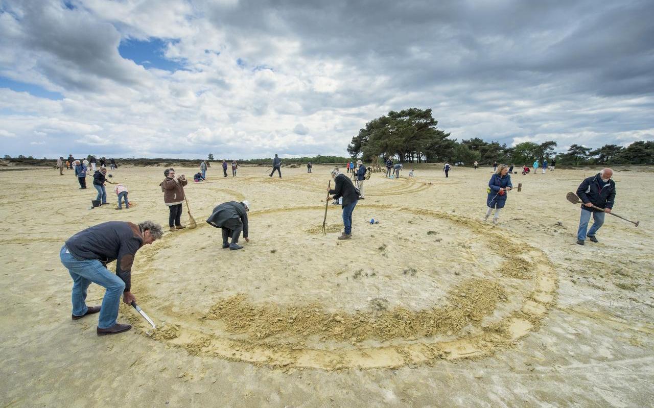 Deelnemers aan een workshop land art van Liesbeth Takken creëren cirkels in het Boerzand van Balloërveld. FOTO MARCEL JURIAN DE JONG