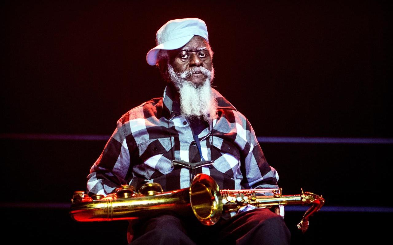 Pharoah Sanders (78) rustte tussen zijn solo’s door even uit op een stoeltje. Foto Corné Sparidaens
Pharoah Sanders (78) rustte tussen zijn solo’s door even uit op een stoeltje. Foto Corné Sparidaens