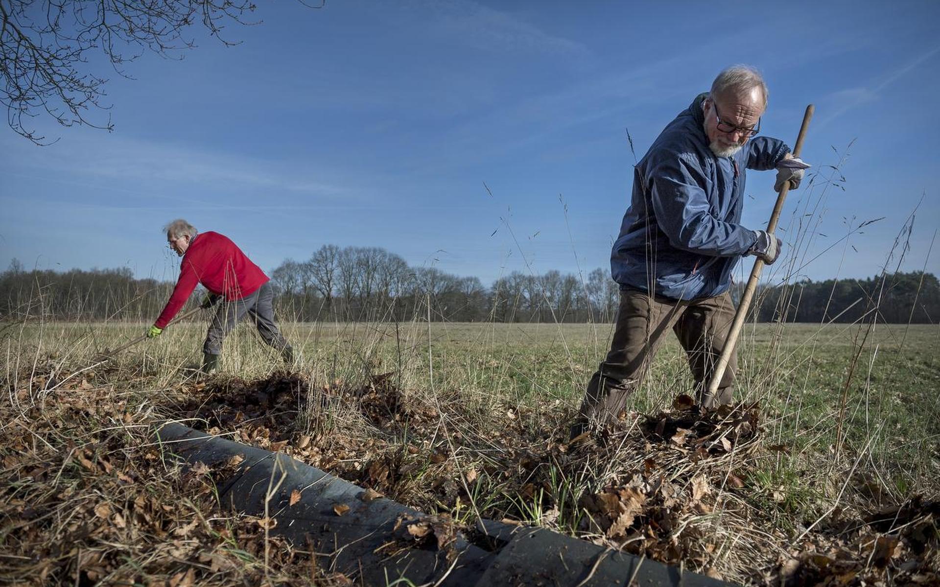 Henk Hellema en Tom Schulte maken de paddenschermen bladvrij