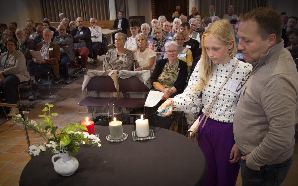 Sybe en Femke Bakker steken een kaars aan ter nagedachtenis aan de tewerkgestelden.