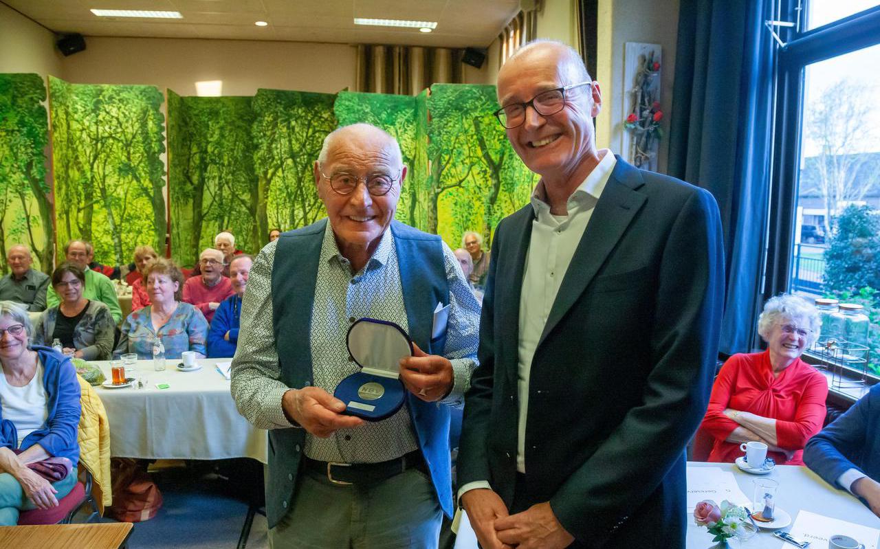 Henk Pries kreeg vrijdagavond in Ruinen tot zijn eigen verrassing een plaquette uitgereikt door zijn eigen zoon Frens, die bijenlector is.