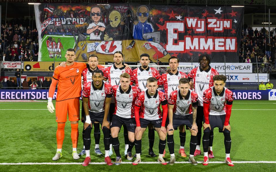 Supporters en spelers met een levensgroot spandoek op de Zuidtribube: 'Wij zijn FC Emmen'. 