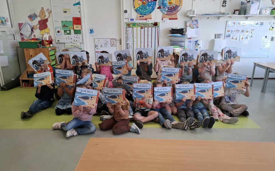 De kinderen duiken allemaal in hun nieuwe boek over de walvis.