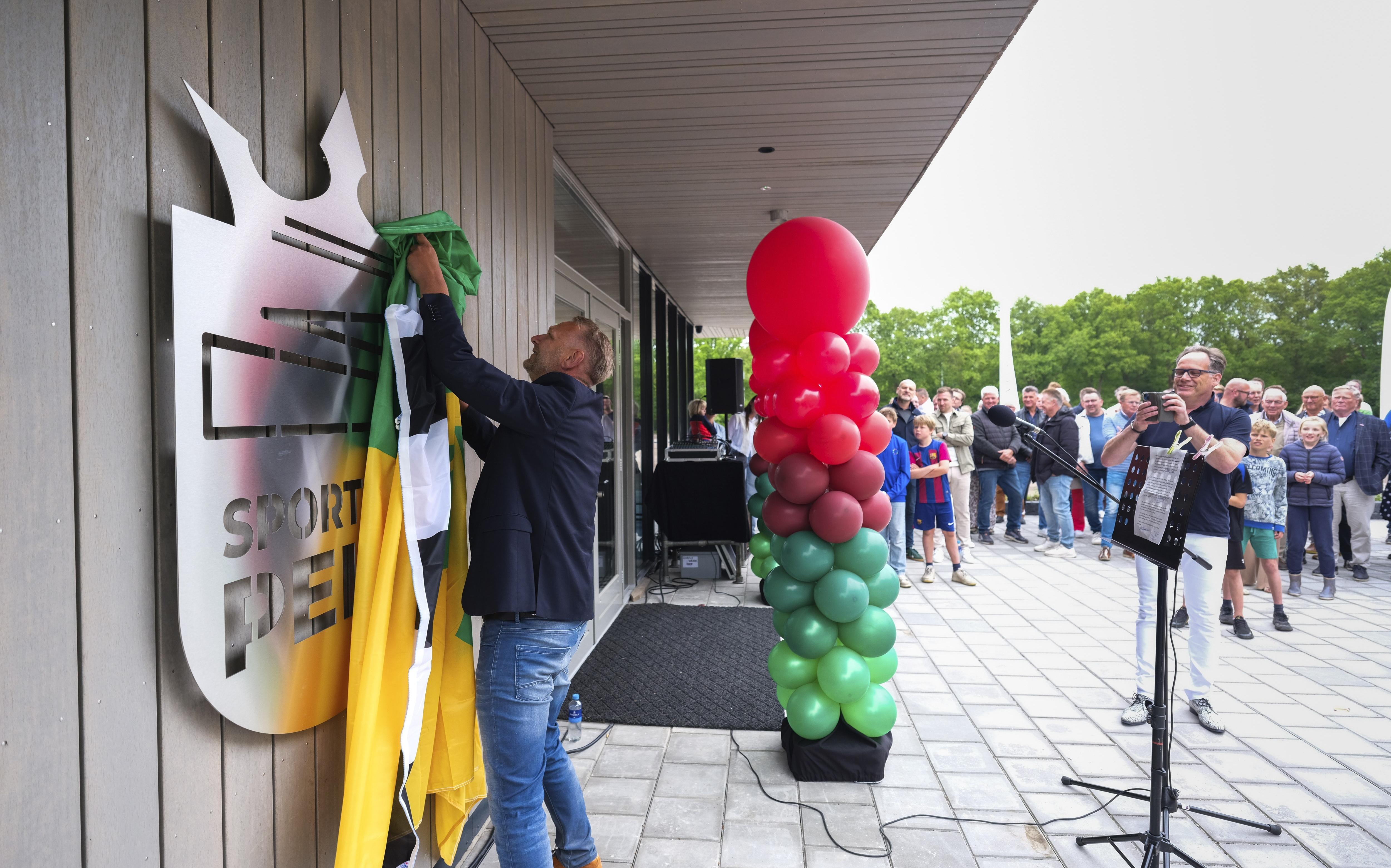 De officiele opening van het Sporthuis in Peize. Wethouder Alex Wekema van Noordenveld onthult het nieuwe logo.