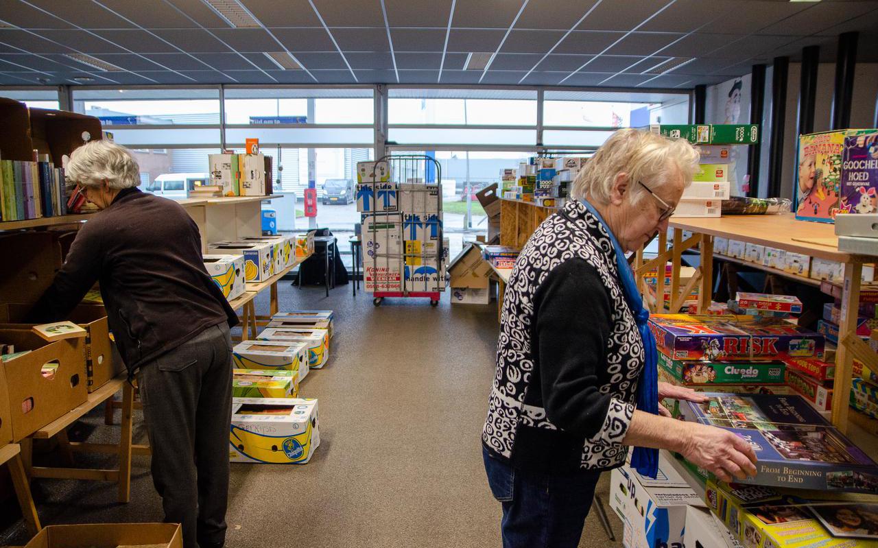 Geke Buist en Else Janssen helpen mee met het inrichten van de enorme boekenmarkt.