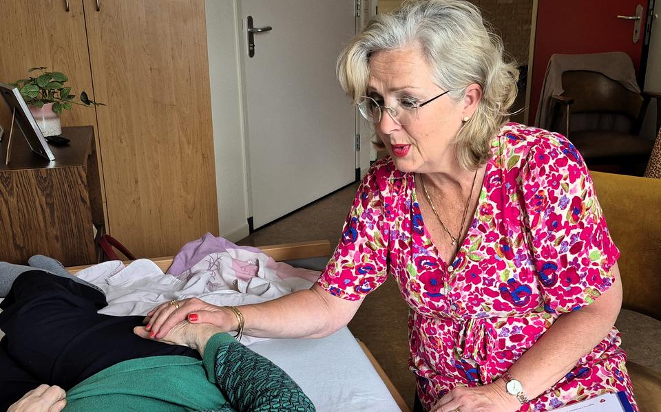 Zorgzangeres Dia Vos aan het bed bij een bewoonster van De Bleerinck in Emmen.