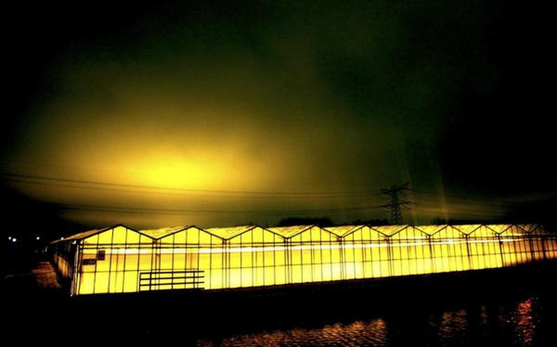 Kassen overstralen de avondlucht boven het Westland. ANP FOTO/ROBIN UTRECHT
