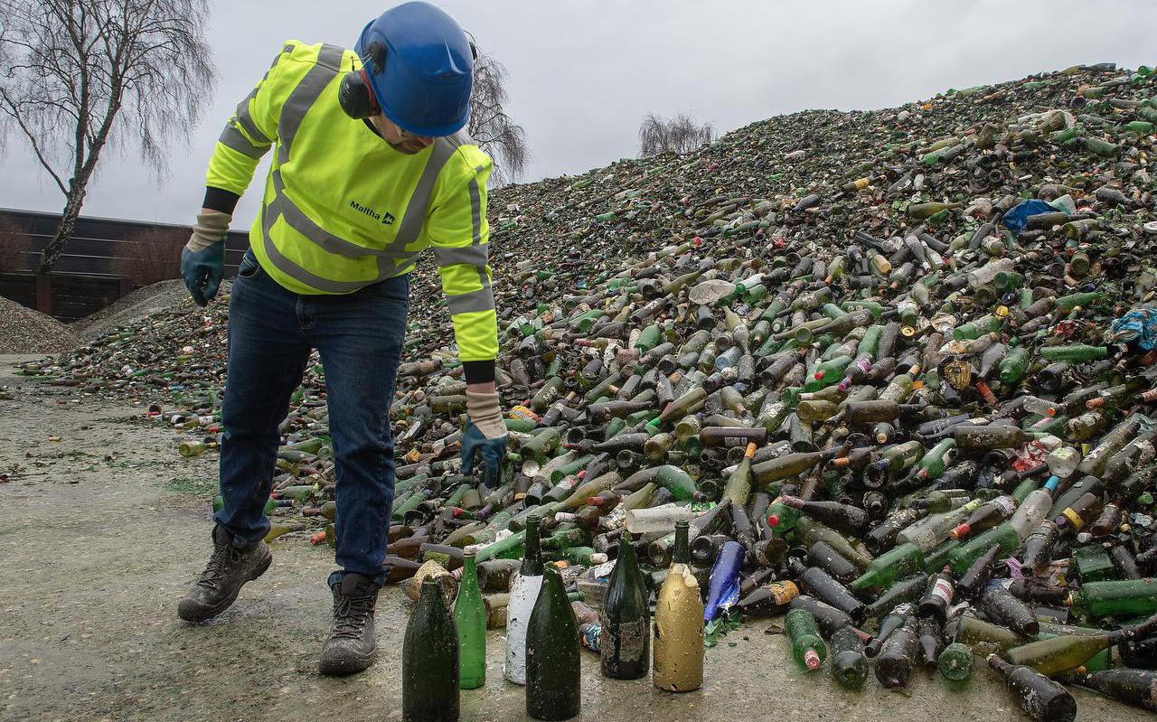 Rolf van der Putten wijst grote groene flessen aan die vaker binnenkomen na de feestdagen.