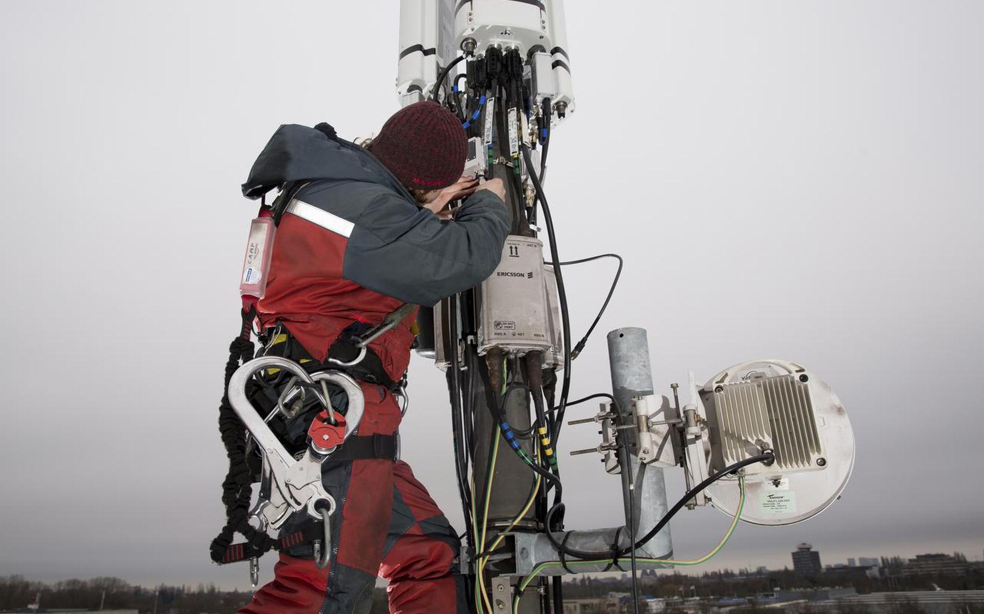 Een monteur aan het werk in een 4G-mast van KPN.