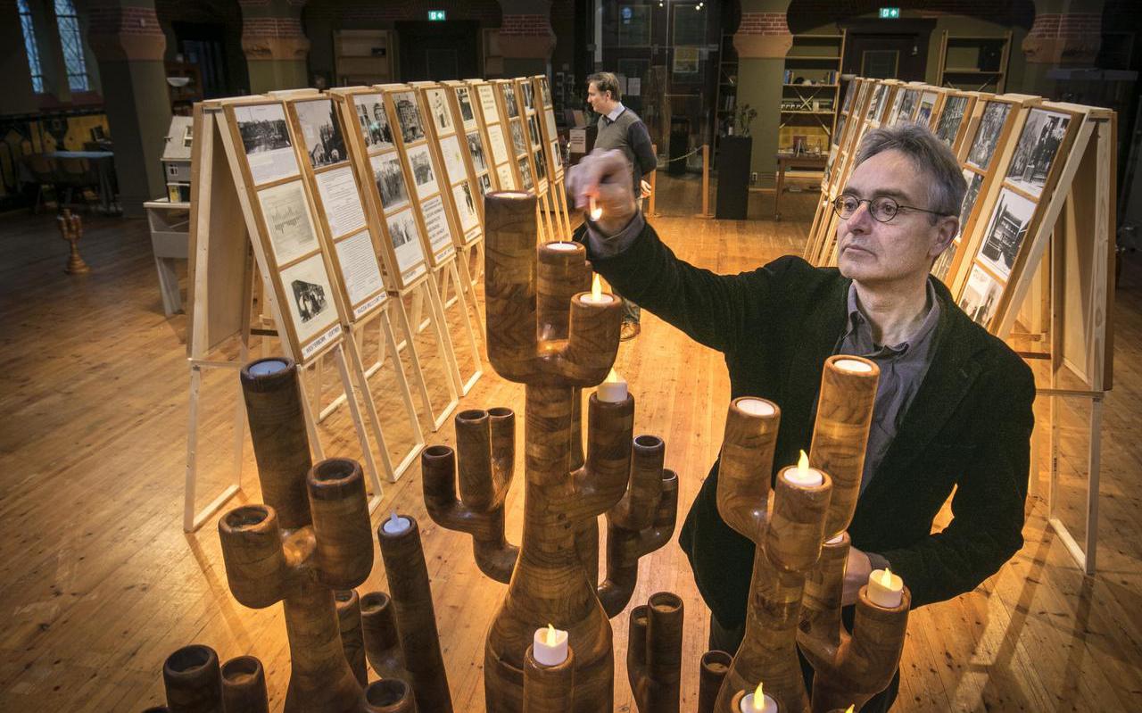 Marcel Wichgers van de Stichting Folkingestraat Synagoge laat een van de houten menora’s zien bij de expositie Onze Stadse Joden van Pieter Oegema.

