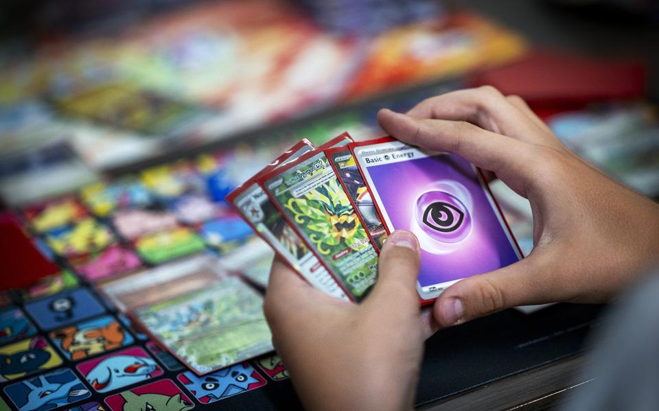 Een speler met een verzameling Pokémon-kaarten tijdens een speltoernooi.
