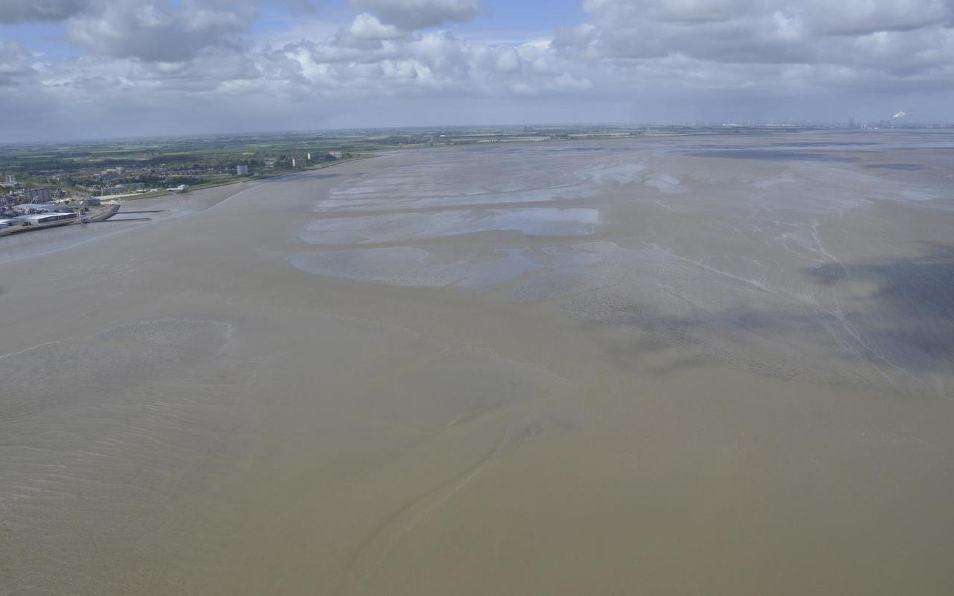 Blik over de Eems en Dollard, met links Delfzijl en op de achtergrond de Eemshaven: ‘invang’ en afzet van baggerslib kan de kwetsbare natuur helpen om zich te herstellen van industrie, scheepvaart en ander menselijk ingrijpen. Foto Rijkswaterstaat