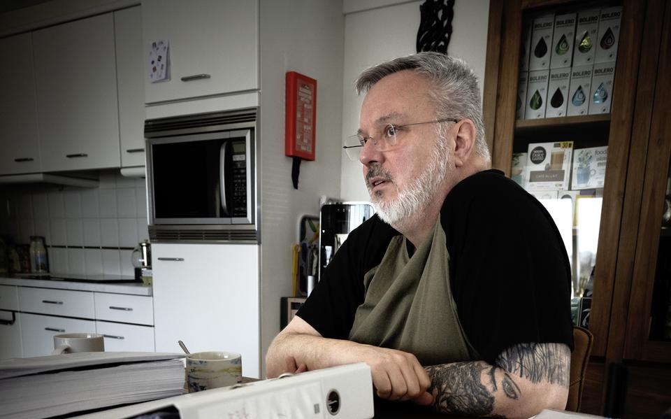 Veteraan Jan Otto aan de tafel vol met documenten over de toekenning van zijn schadevergoeding.