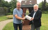 Voorzitter Bert Kolk biedt vrijwilliger Harry Jager gebak aan. Foto: Stichting Hospice Gasthuis-HS.