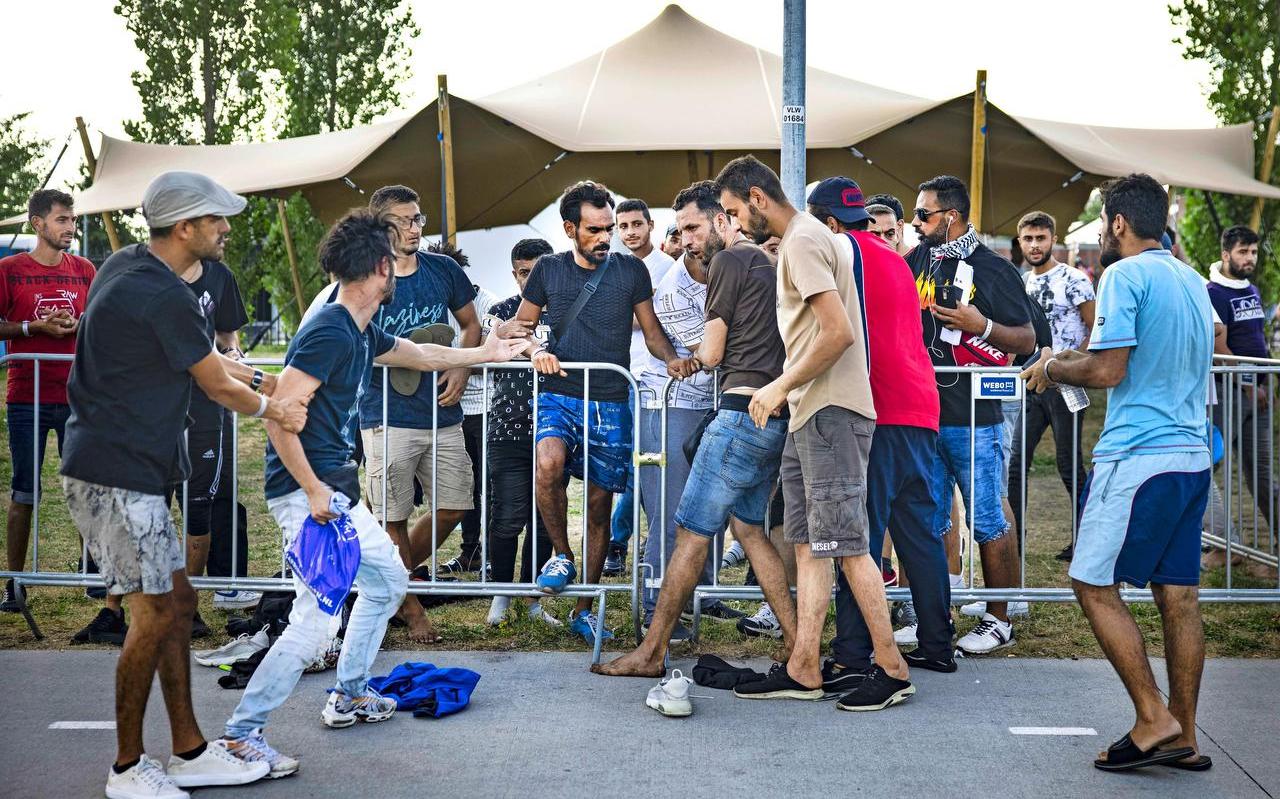 Asielzoekers bij de overvolle opvang in de Groningse plaats waar zondag gevechten uitbraken Asielzoekers bij de overvolle opvang in de Groningse plaats waar zondag gevechten uitbraken