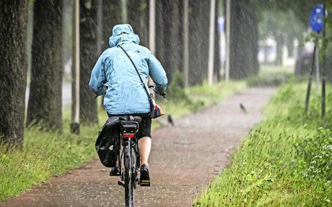 Een fietser trotseert de regen.