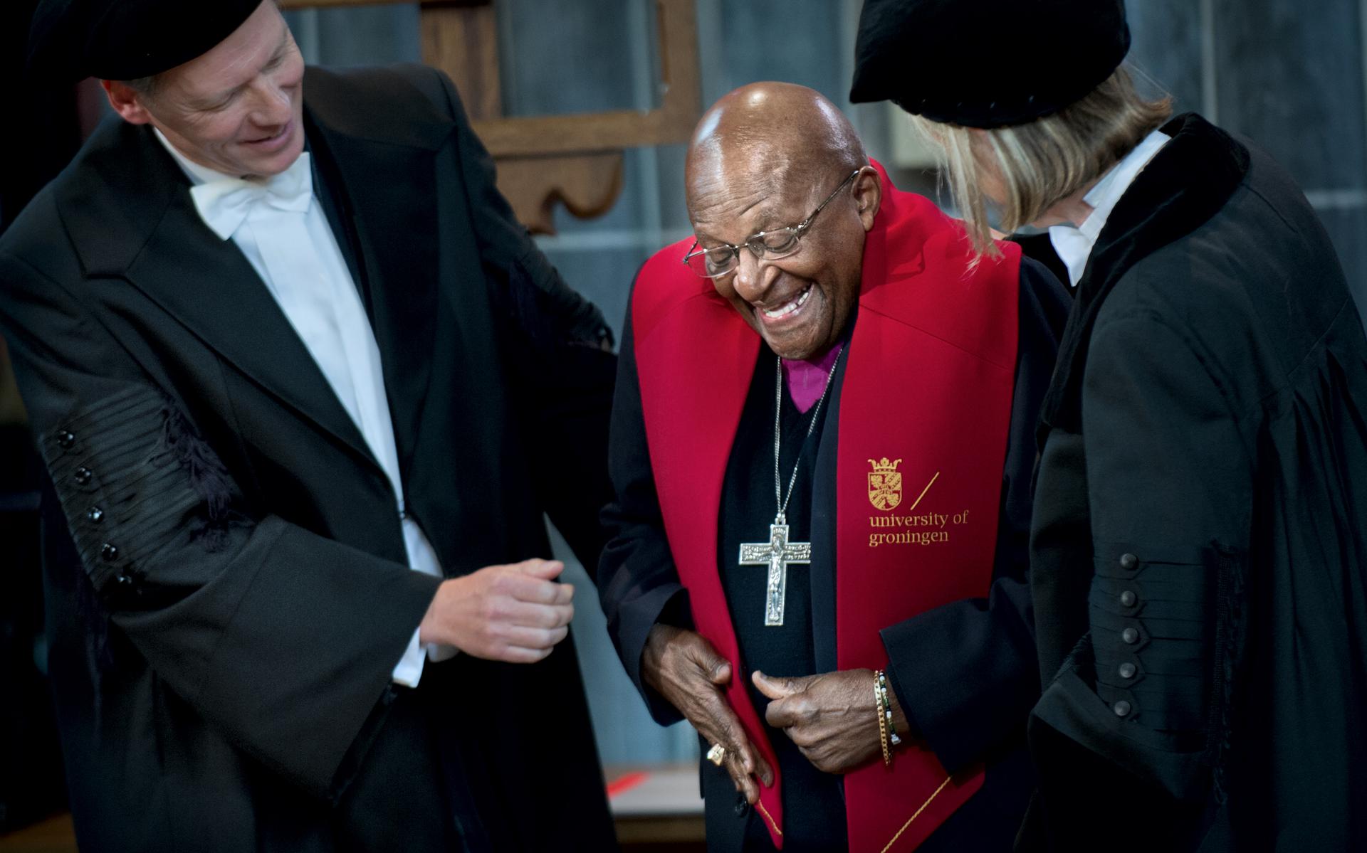 Bisschop Tutu krijgt in 2012 de versierselen omgehangen die horen bij het eredoctoraat van de Rijksuniversiteit Groningen.