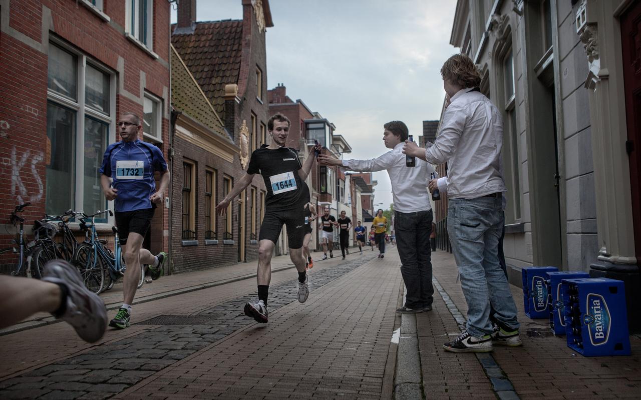 Tijdens hardloopevenement de Nacht van Groningen bieden studenten van studentenvereniging Albertus Magnes de lopers een biertje aan. Tijdens hardloopevenement de Nacht van Groningen bieden studenten van studentenvereniging Albertus Magnes de lopers een biertje aan.