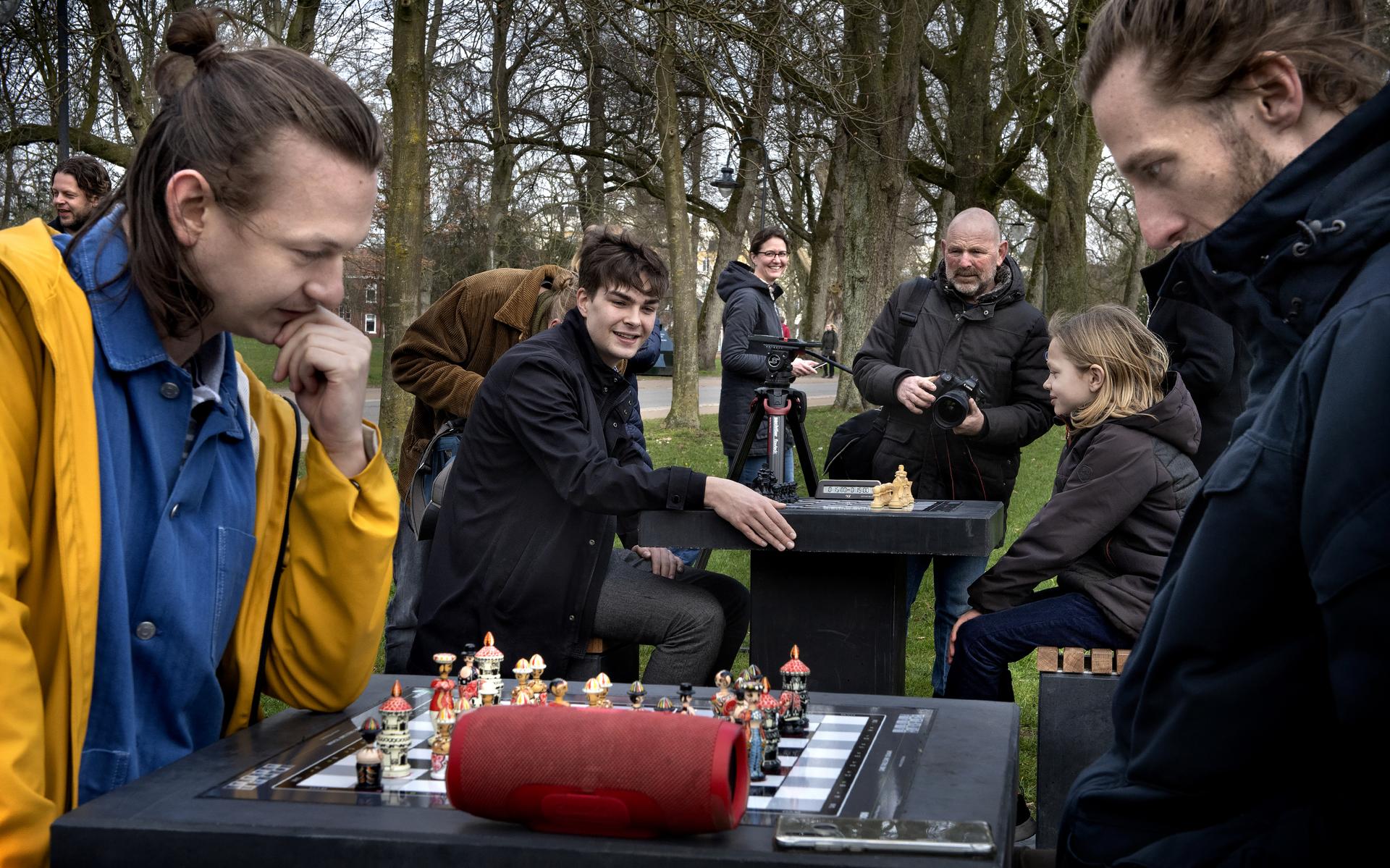 De schaaktafels in het Noorderplantsoen worden ingewijd: De 9-jarige Jort Linnewiel en Jorden van Foreest beginnen aan hun partij, terwijl Davey (gele jas) en Yorrick al druk bezig zijn.