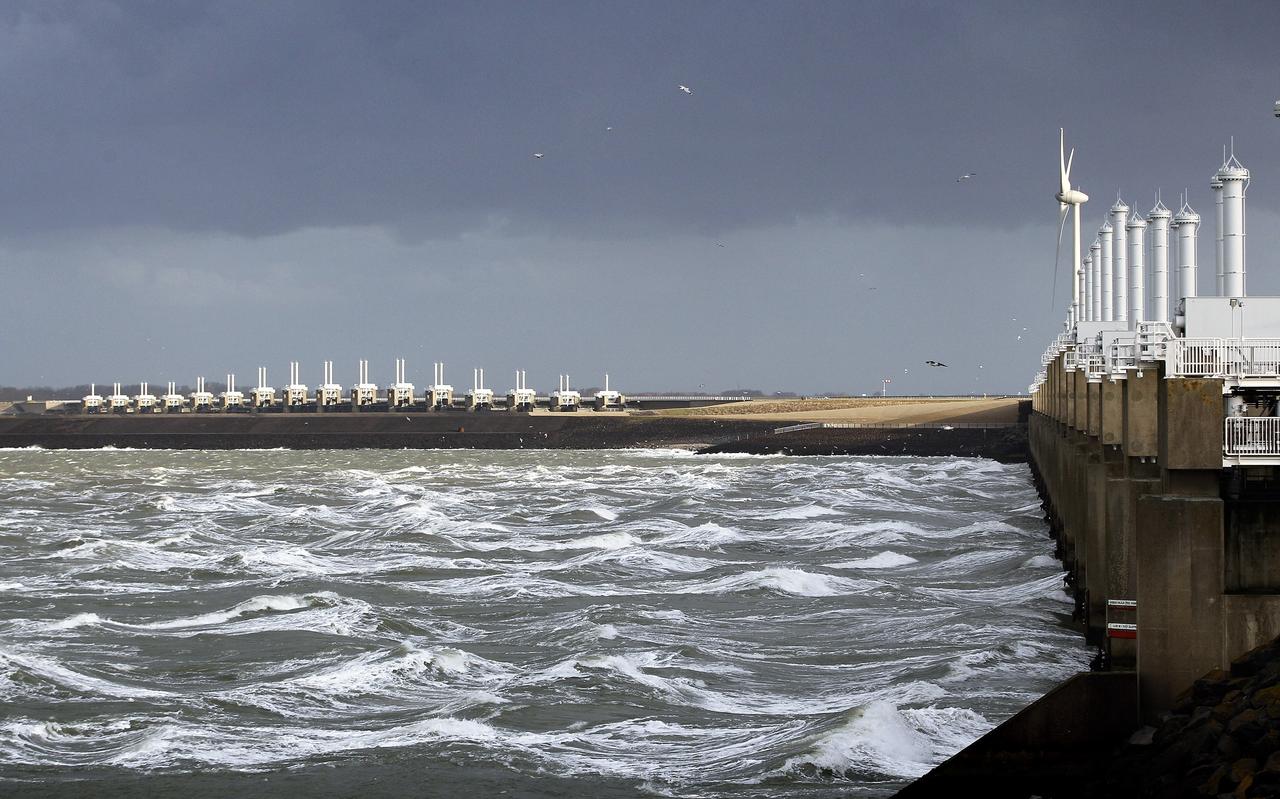 Dreigende luchten boven de stormvloedkering in de Oosterschelde als omslag van het rapport 'Lage drempels, hoge dijken'. Foto: ANP Dreigende luchten boven de stormvloedkering in de Oosterschelde als omslag van het rapport 'Lage drempels, hoge dijken'. Foto: ANP