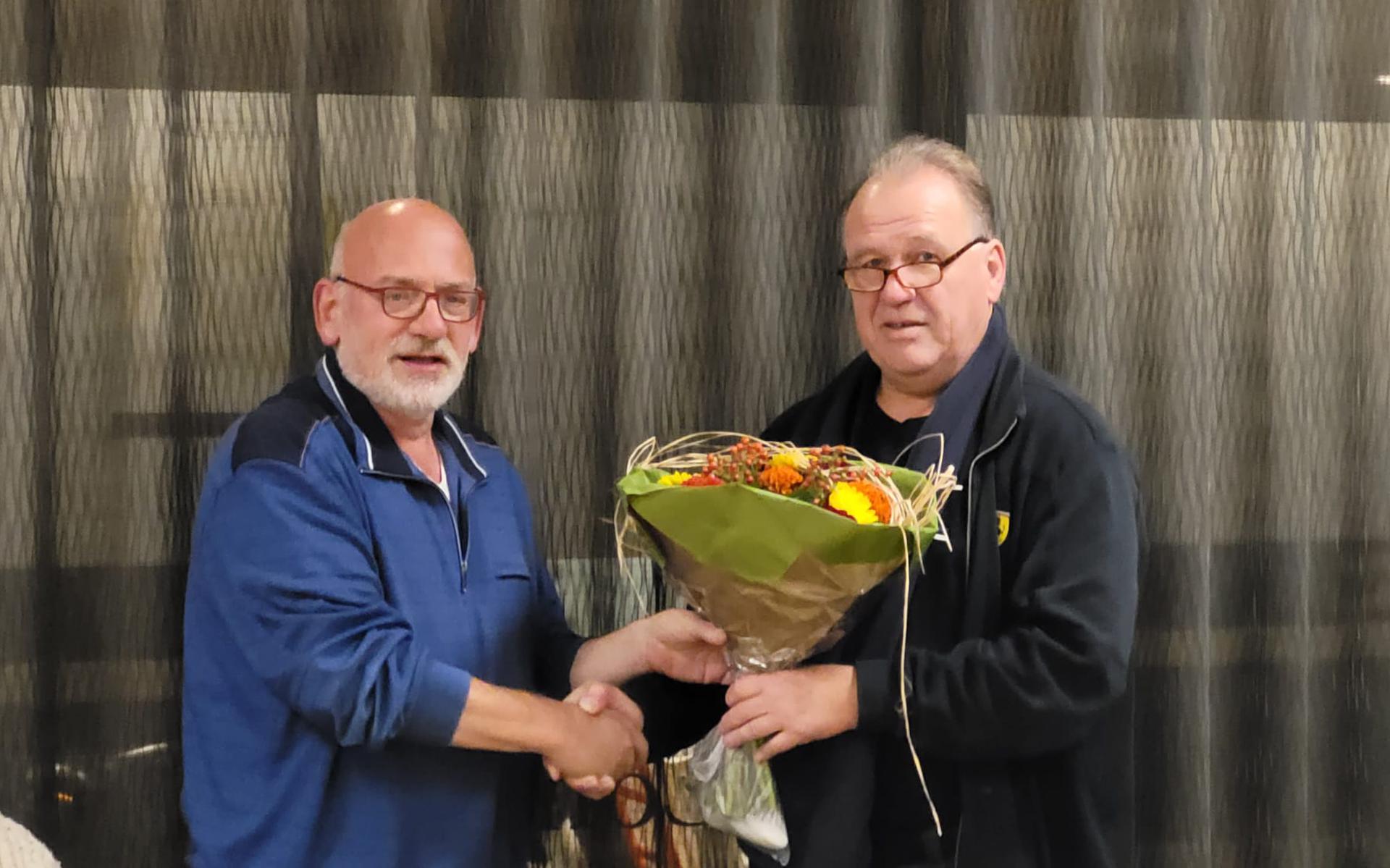 Henk Santing krijgt bloemen van Plop-voorzitter Ruud Wiersema.