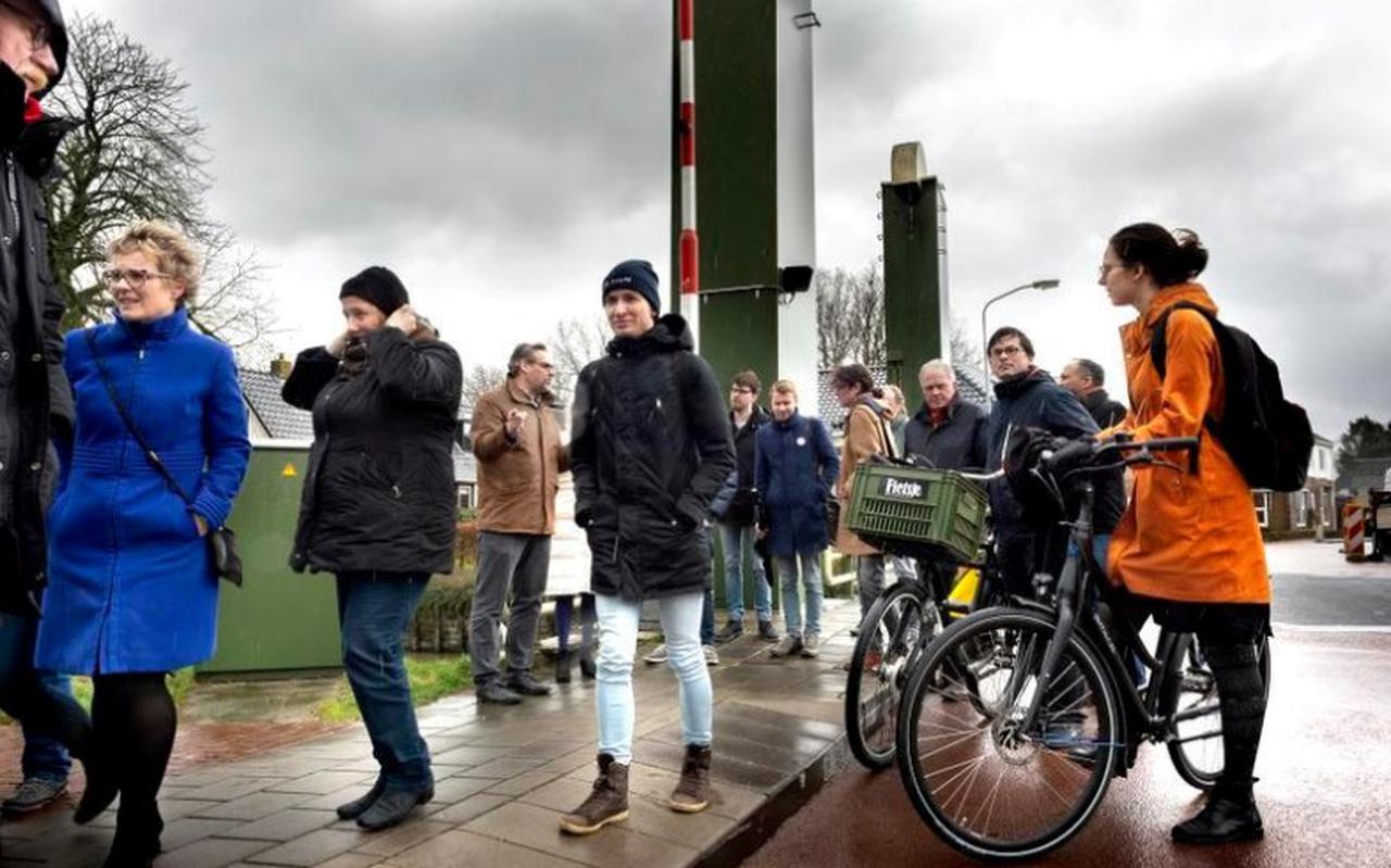 De delagatie van de gemeenteraad in weer en wind op de brug over het Damsterdiep in Ten Post. Foto :Peter Wassing