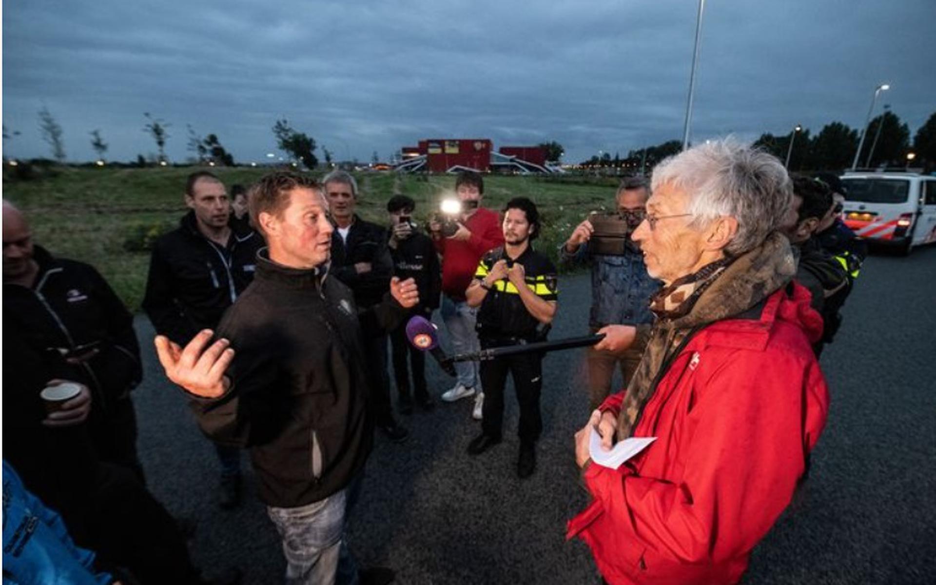 Achterhoekse boeren zoeken milieuactivist Johan Vollenbroek (rechts) op om met hem in discussie te gaan.