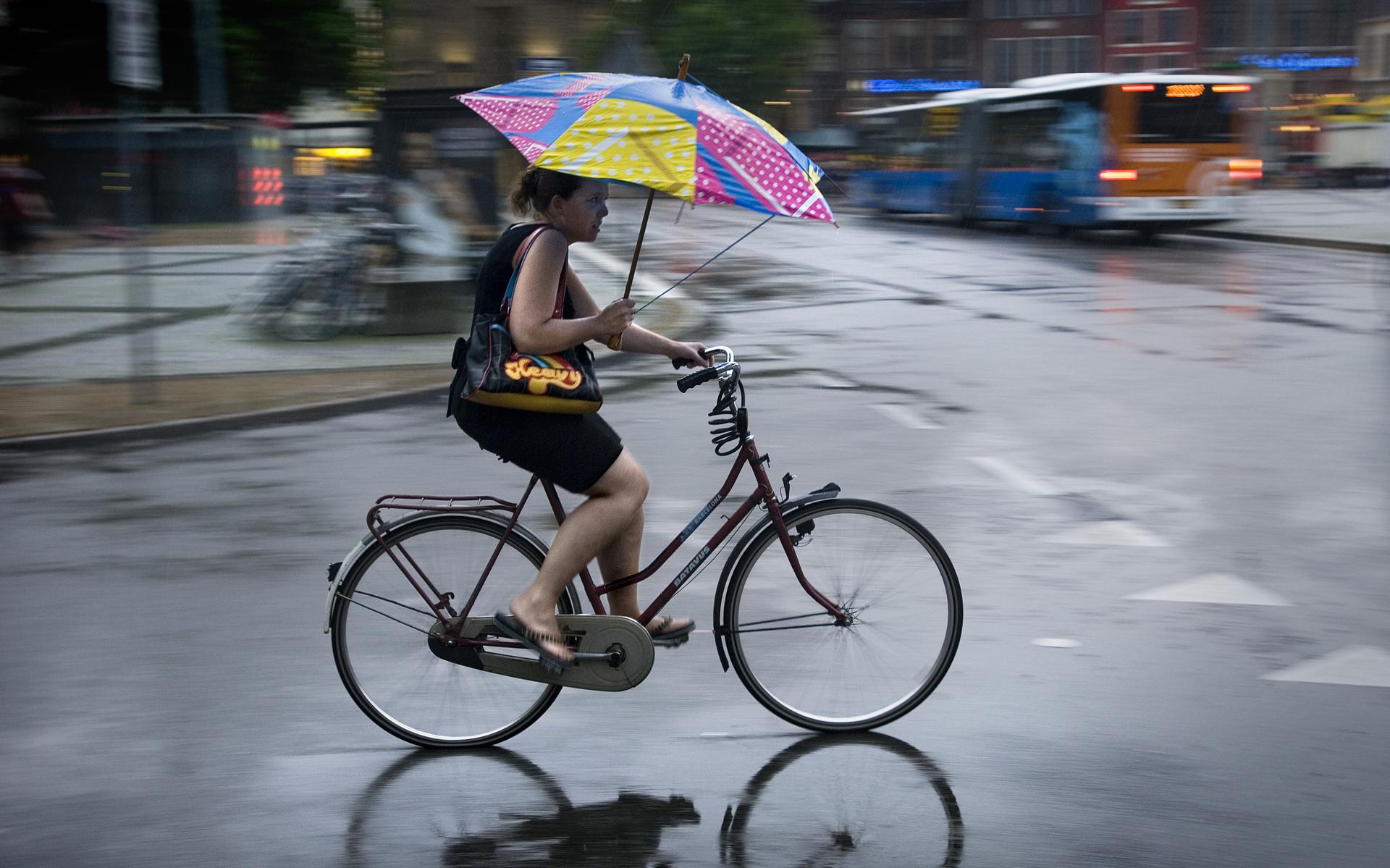 Een fietsster trotseert de regen. Foto: Archief DvhN/Corné Sparidaens