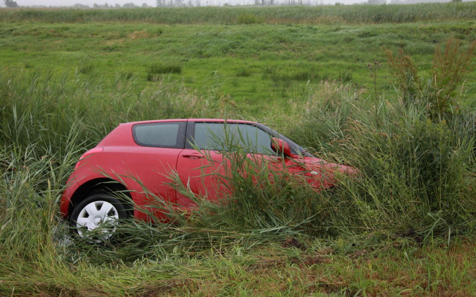 Auto belandt in sloot naast Groningerweg bij Peize. Bestuurder raakt gewond, hond blijft ongedeerd