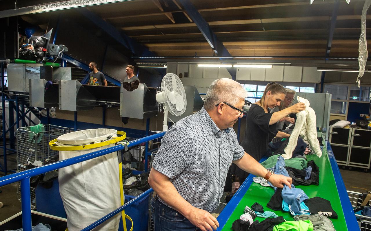 Kledingsorteerder Sympany neemt nieuwe sorteermachine in gebruik. Links Reggie Silanoe. Kledingsorteerder Sympany neemt nieuwe sorteermachine in gebruik. Links Reggie Silanoe.