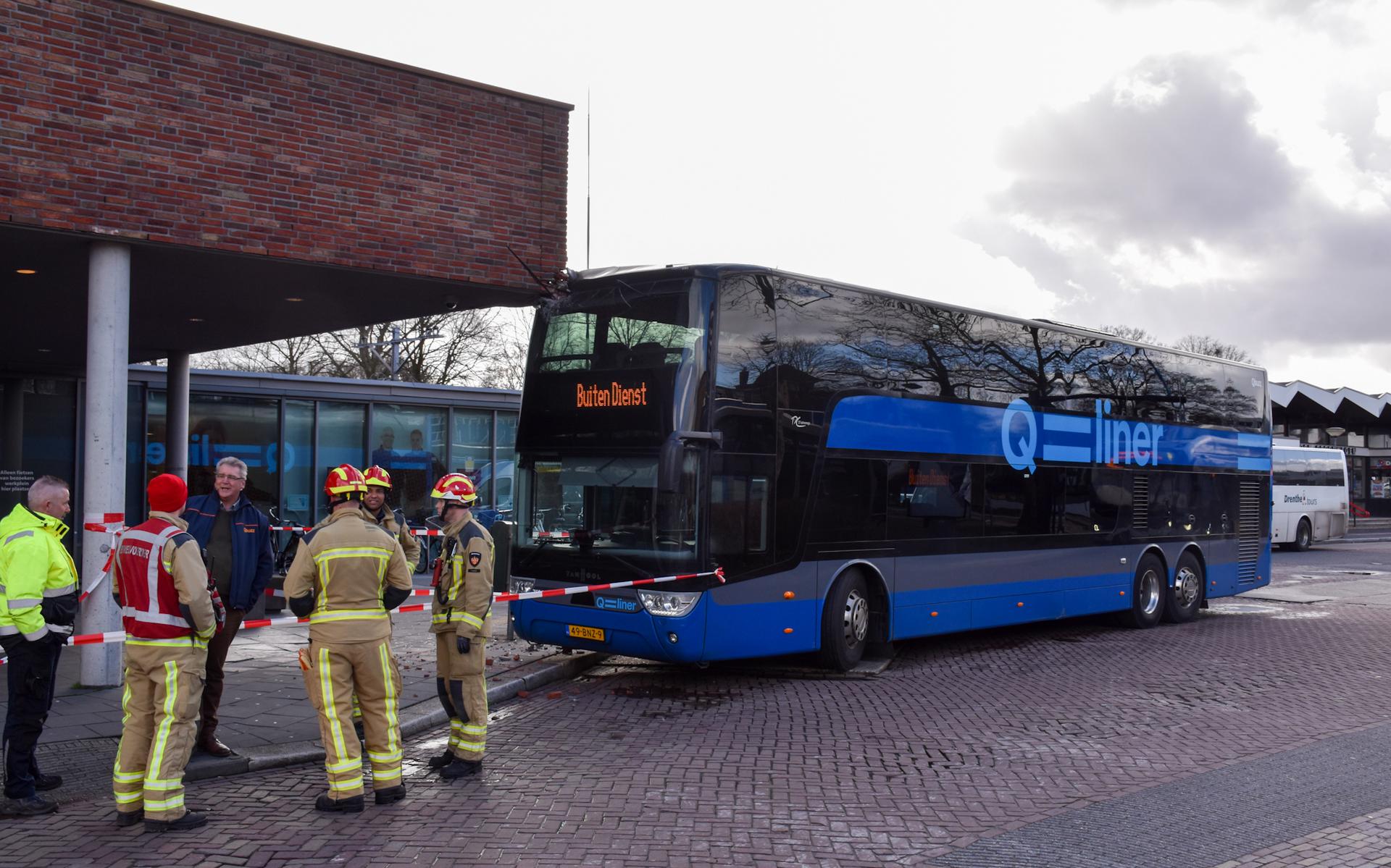 De Qbuzz tegen het gebouw van UWV in Emmen. De vrees bestaat dat de gevel instort als de bus eronder wordt weggehaald. 