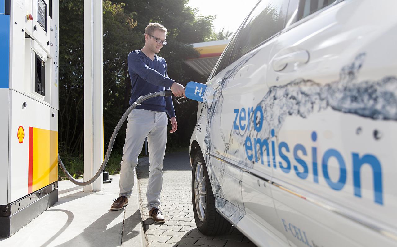 Een man vult de tank van zijn auto met waterstof.